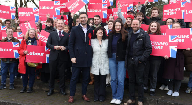 New Labour MP Damien Egan surrounded by supporters waving red Labour placards