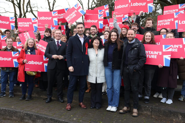 New Labour MP Damien Egan surrounded by supporters waving red Labour placards