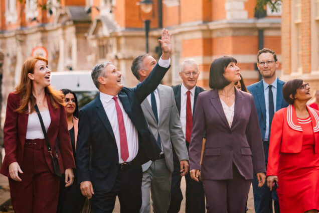 Keir Starmer and members of the Shadow Cabinet looking up and to the left to wave to someone out of shot