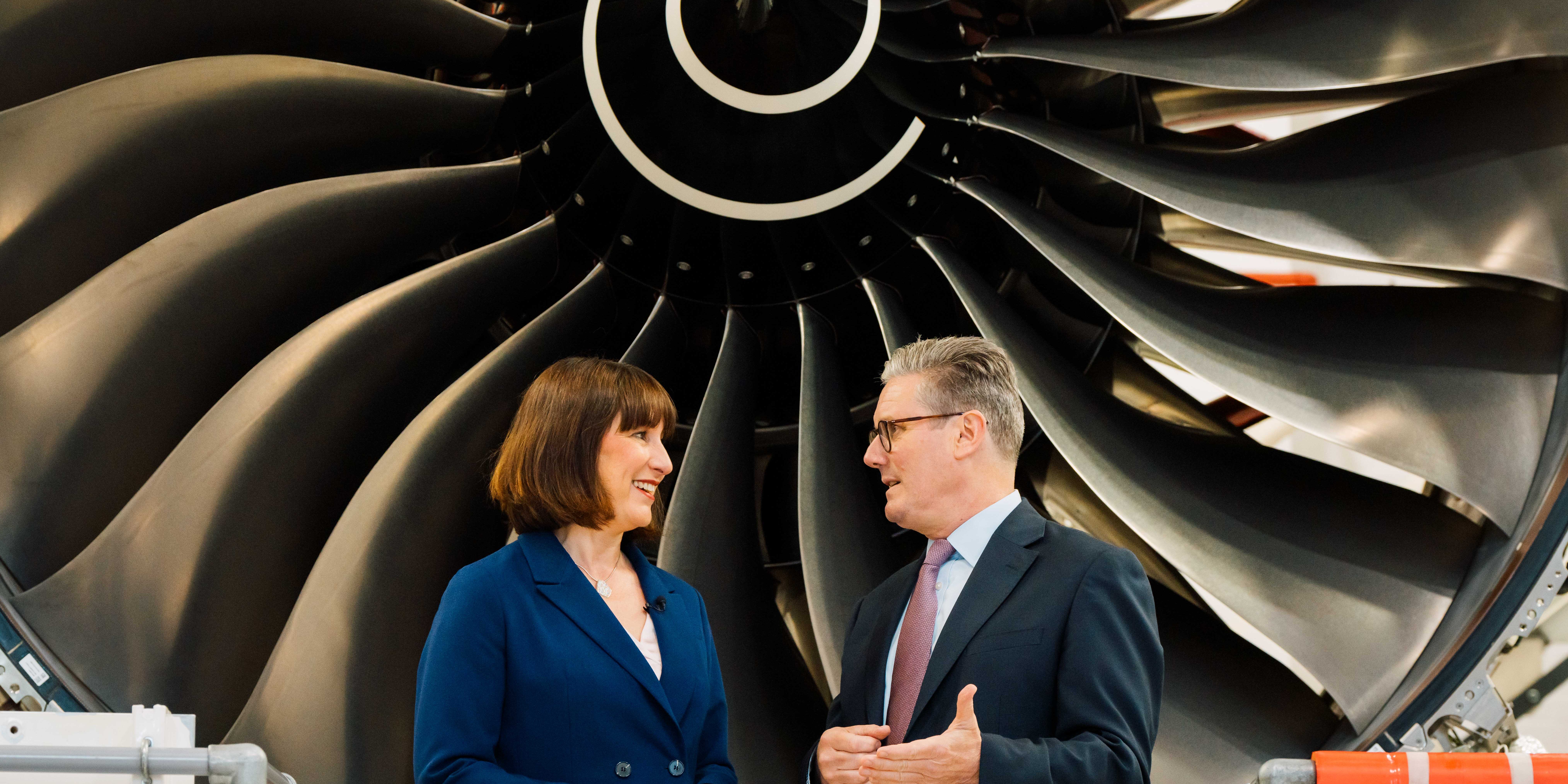 Rachel Reeves and Keir Starmer facing each other in front of a turbine.