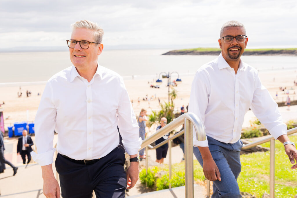 Keir Starmer and Vaughan Gething walk side by side by a beach