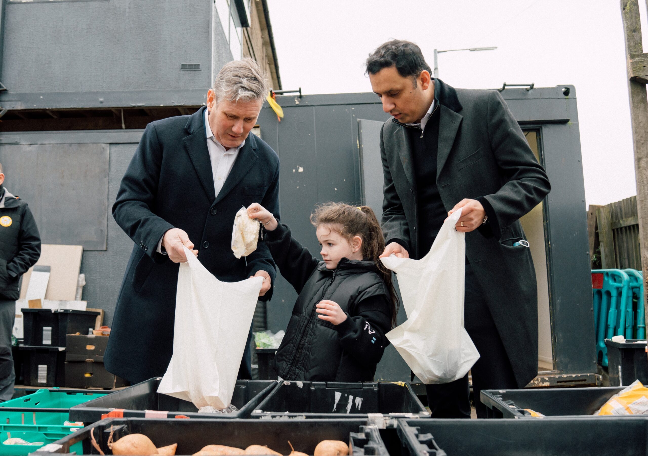 Keir Starmer, Anas Sarwar and a girl putting shopping in a plastic bag