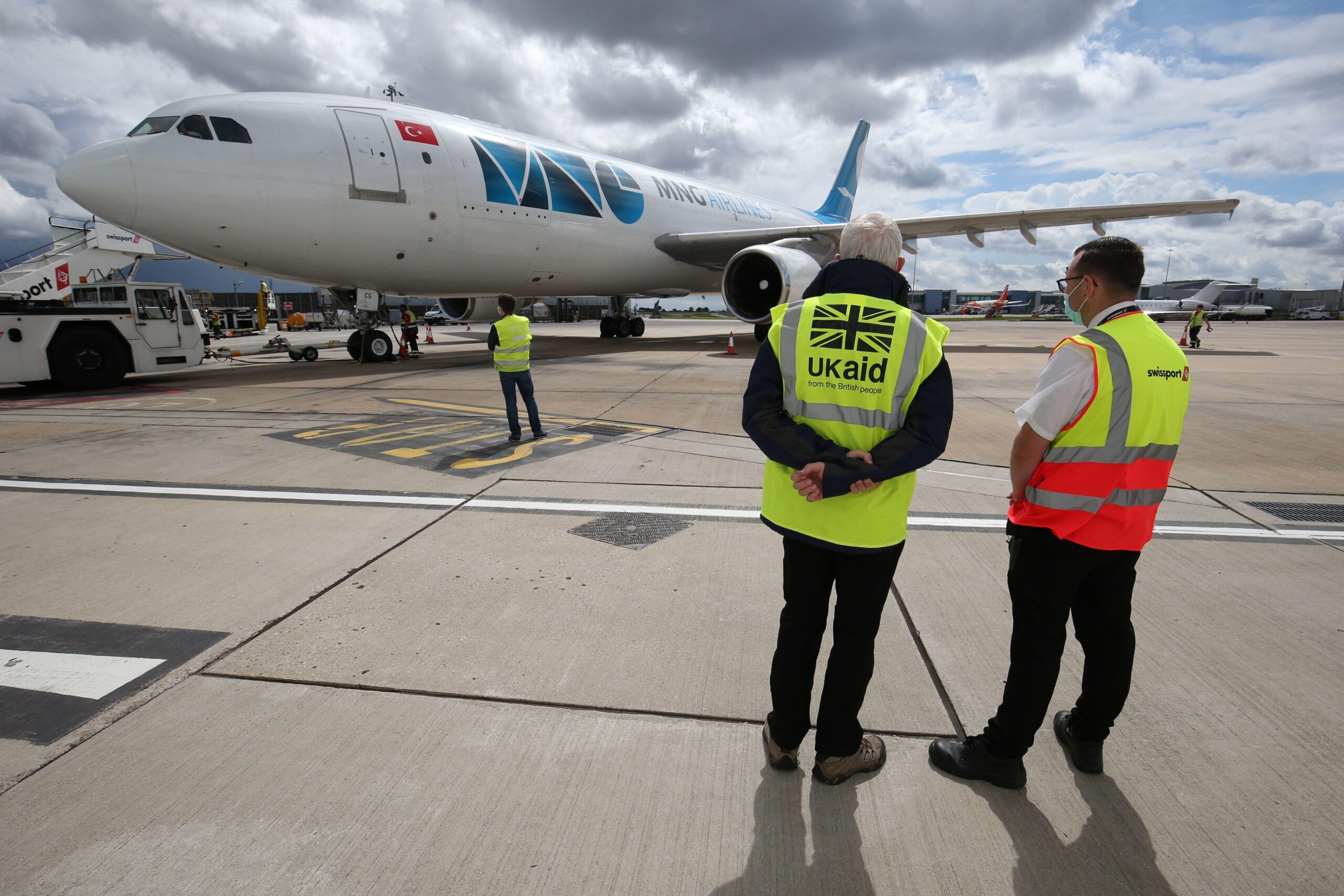 A Department for International Development logistician observing the departure of a jet containing a consignment of surplus medical supplies bound for Beirut at Luton Airport.