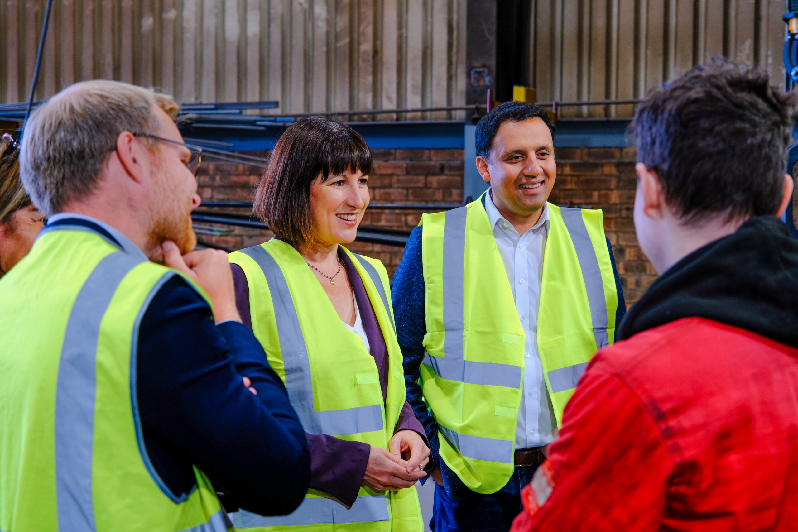 Anas Sarwar and Rachel Reeves in high vis vests talk to a group of people