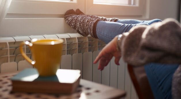 A woman with her feet up on a radiator