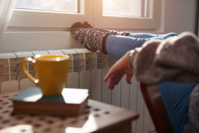 A woman with her feet up on a radiator