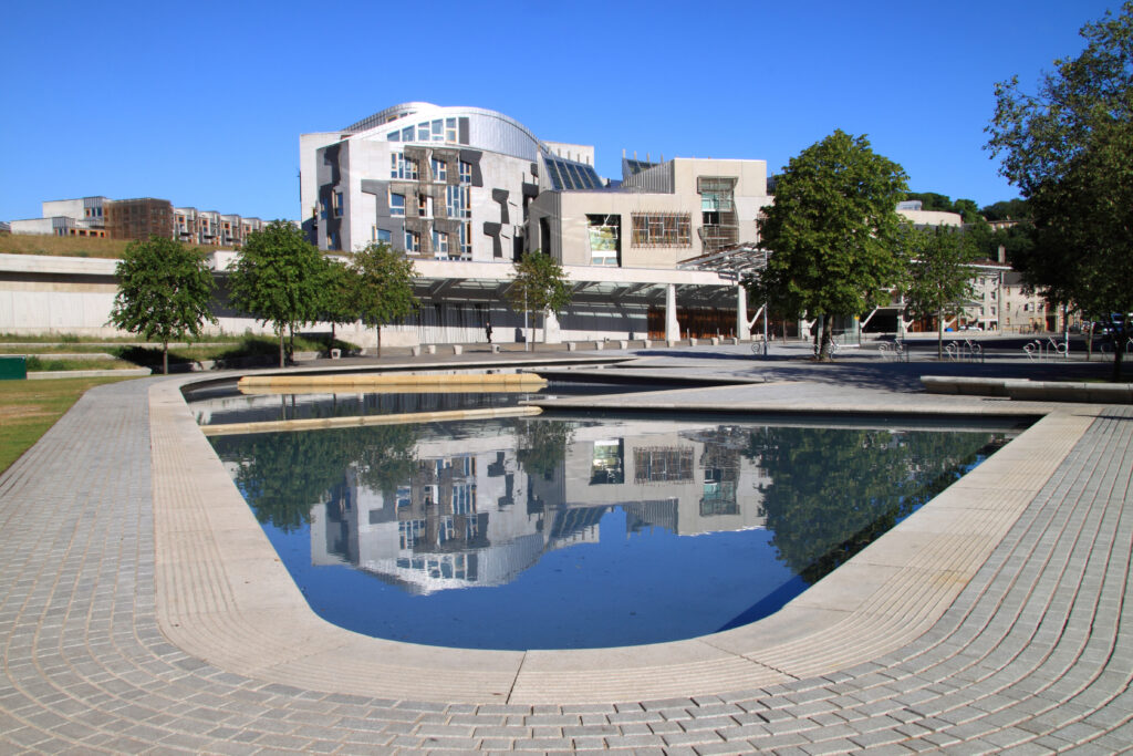 A shot of the Scottish Parliament building in Holyrood, Edinburgh, across a pond.