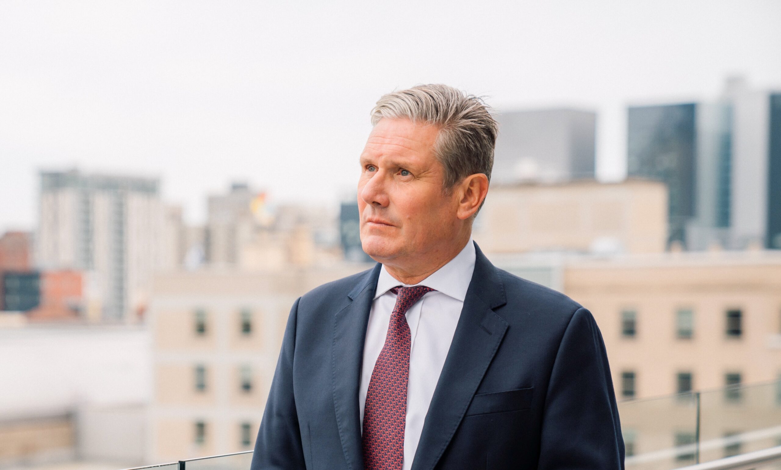 A portrait of Keir Starmer wearing a suit and tie.