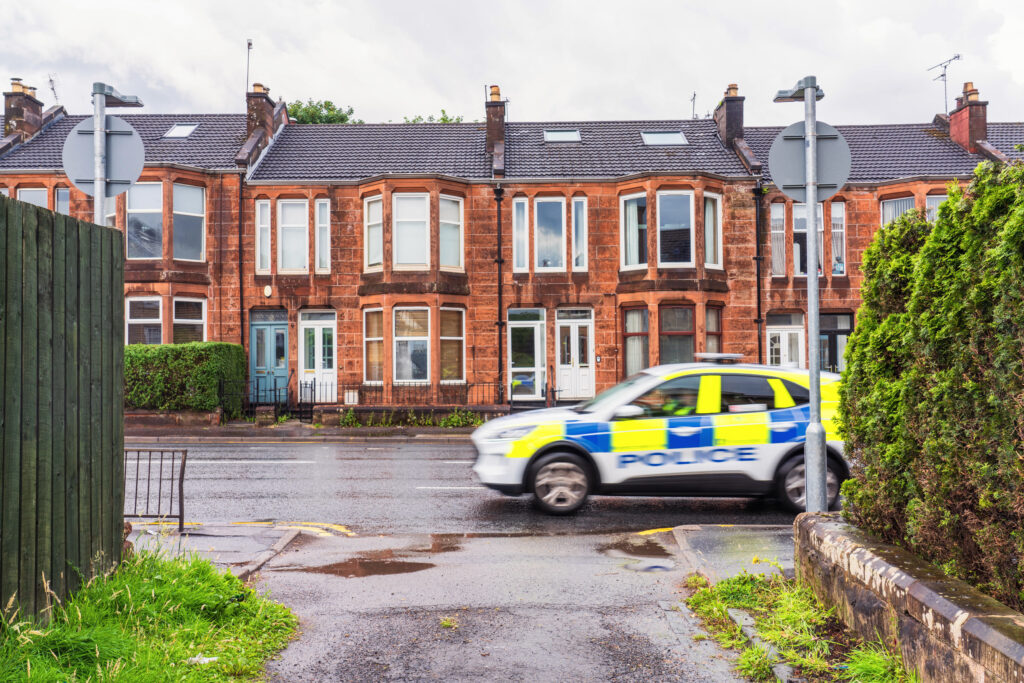 A police car passes a lane on Crow Road in Jordanhill, Glasgow.