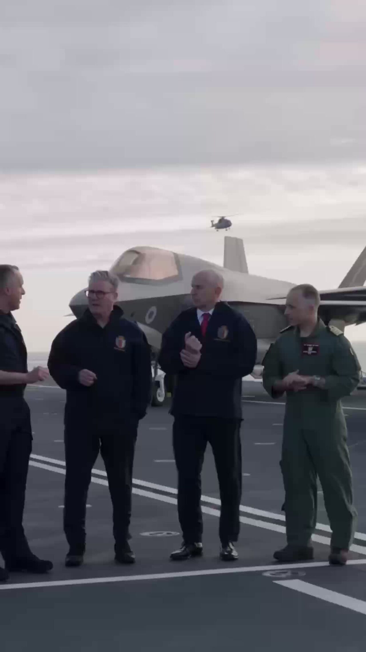 Prime Minister Keir Starmer and Defence Secretary John Healey standing in front of a fighter jet on an aircraft carrier
