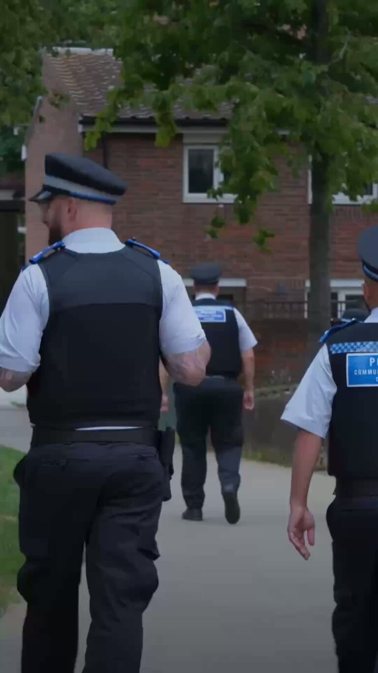 Police officers walking through a neighbourhood