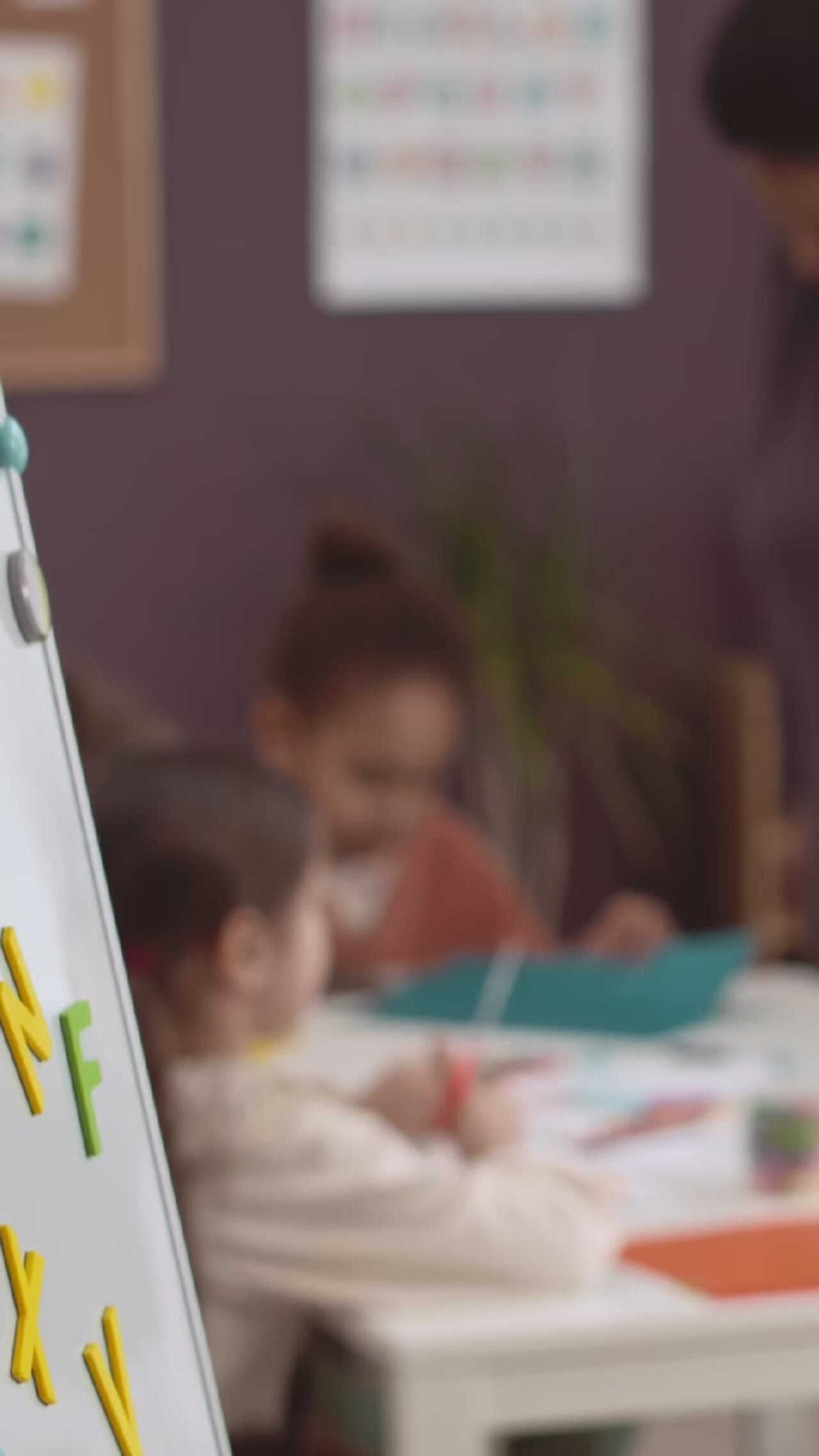 A white board in a nursery with magnetic letters on it