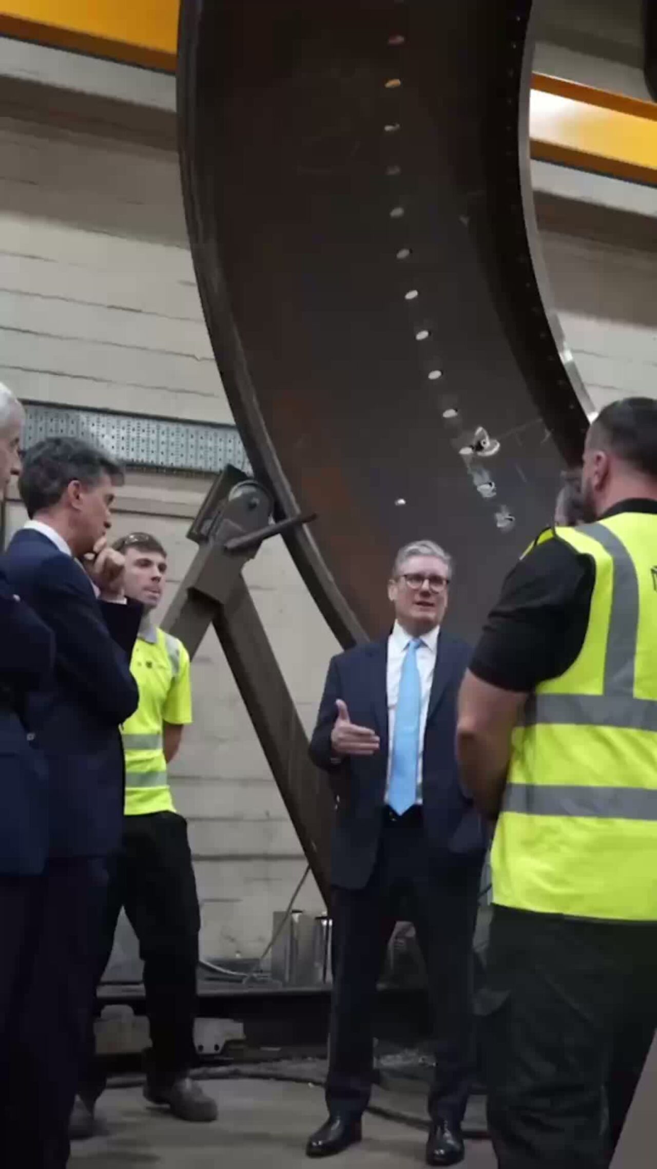 Prime Minister Keir Starmer and Energy Secretary Ed Miliband talking to some people at a factory.
