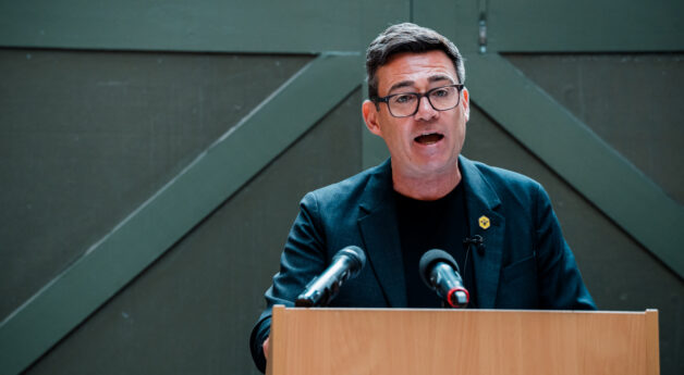 Andy Burnham speaking at a podium